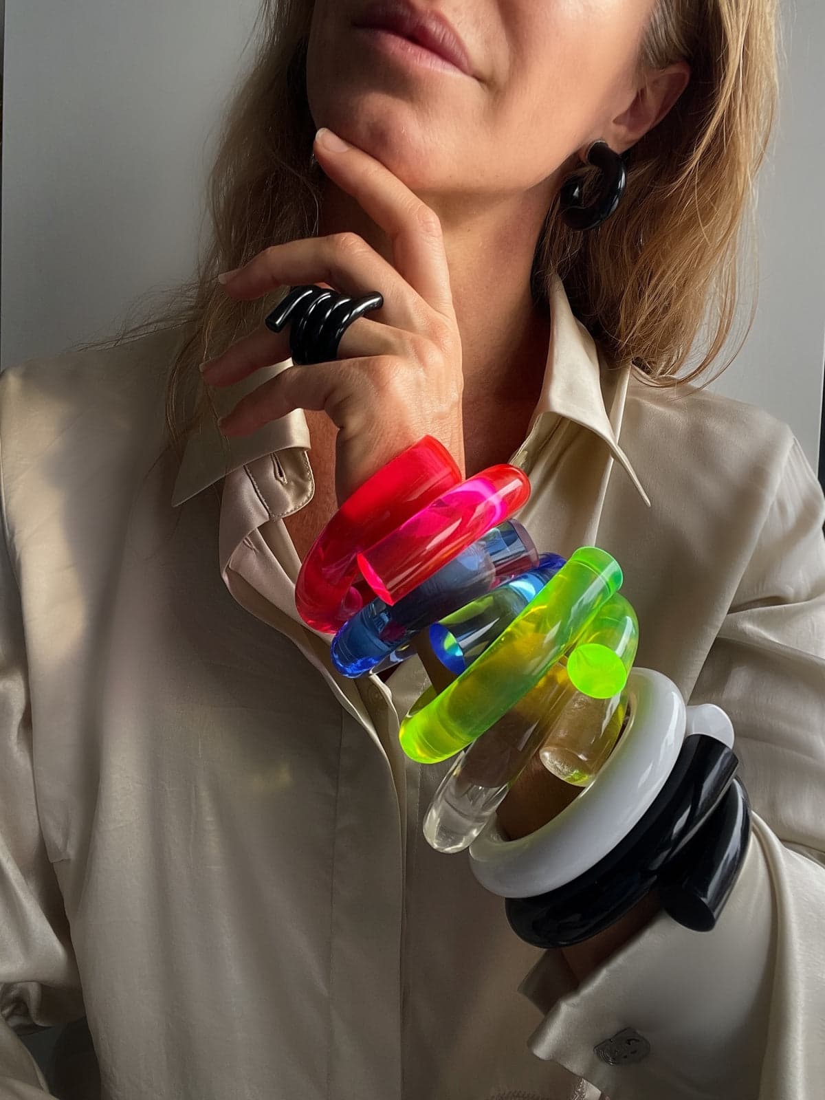 Stack of colourful Chofa Jewelry hand-poured lucite bangles worn on the wrist